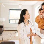 Doctor talking to man holding baby