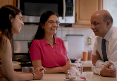 family sitting in kitchen talking