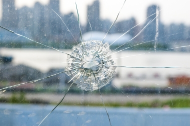 Pane of glass with bullet hole in it