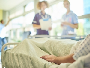 Patient in hospital bed talking to nurses