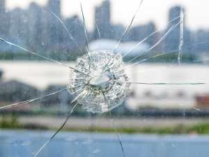 Pane of glass with bullet hole in it