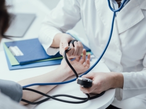 Doctor taking and employee's blood pressure