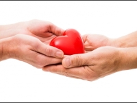 Person giving a heart figure to another person